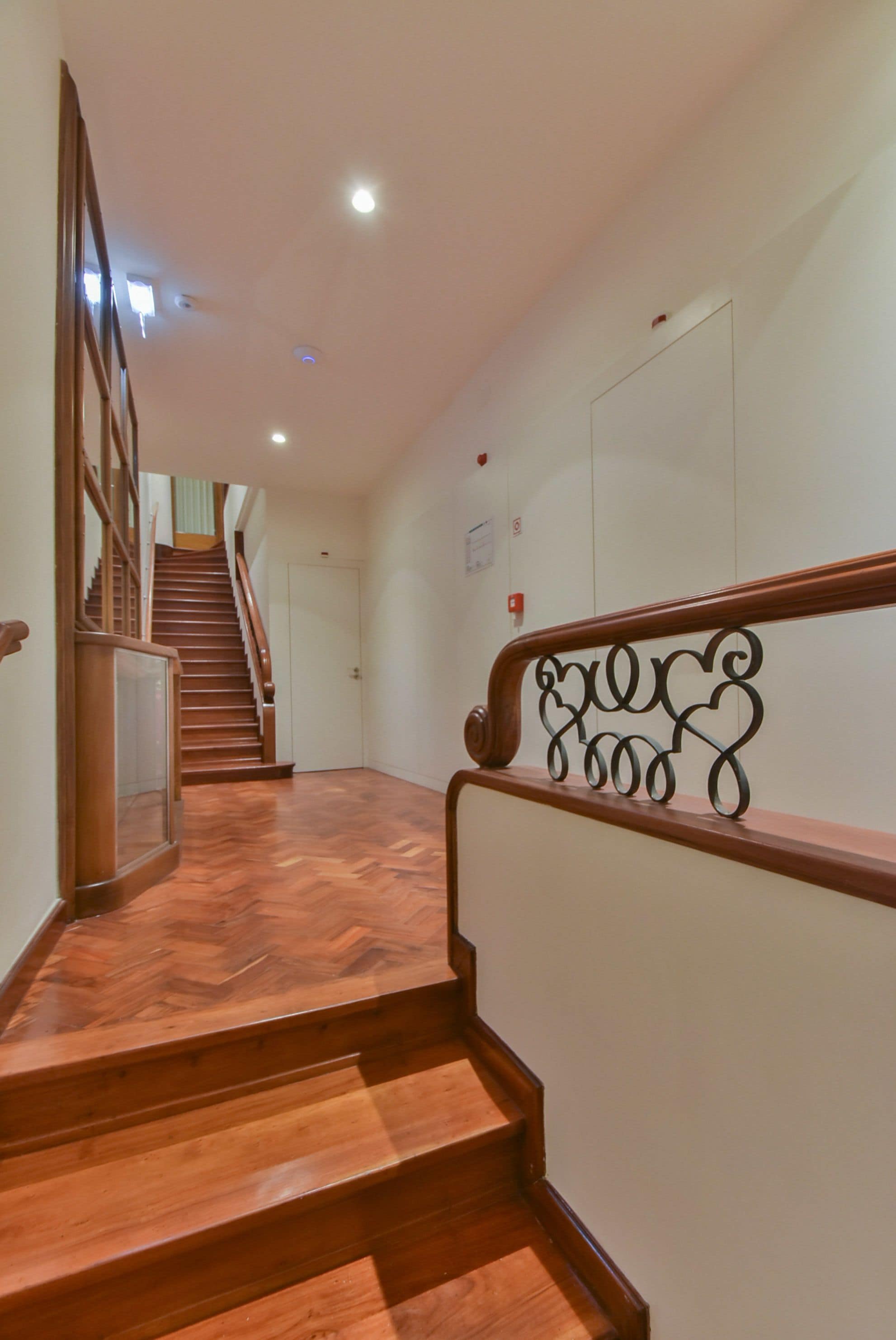 A wooden staircase with a metal railing leading to a door at the top.