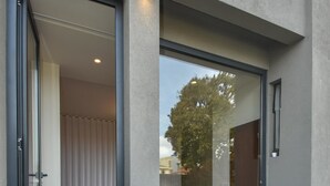 A modern hotel room with a sliding glass door leading to a balcony, a wooden floor, and a view of the outdoors. - República 157 (Porto)