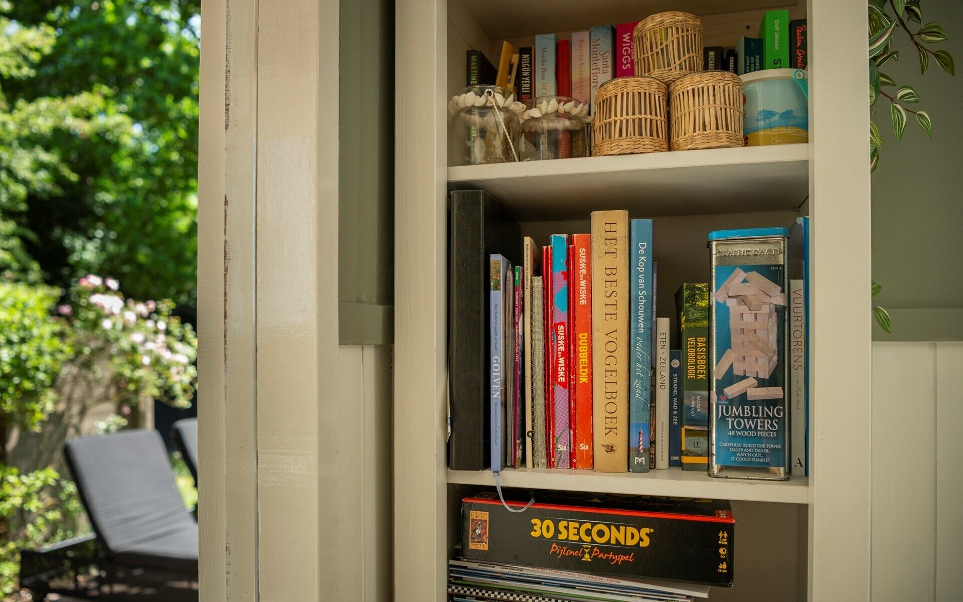 Une bibliothèque remplie de divers livres et un jeu de société.