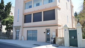 A multi-story building with a beige facade, large windows, and a gated entrance.