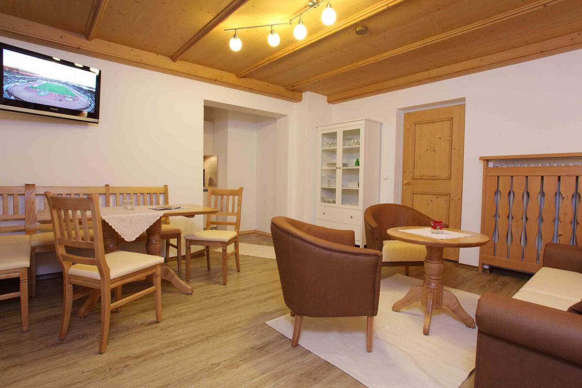 Une pièce meublée de meubles en bois, avec un téléviseur et un meuble de rangement.