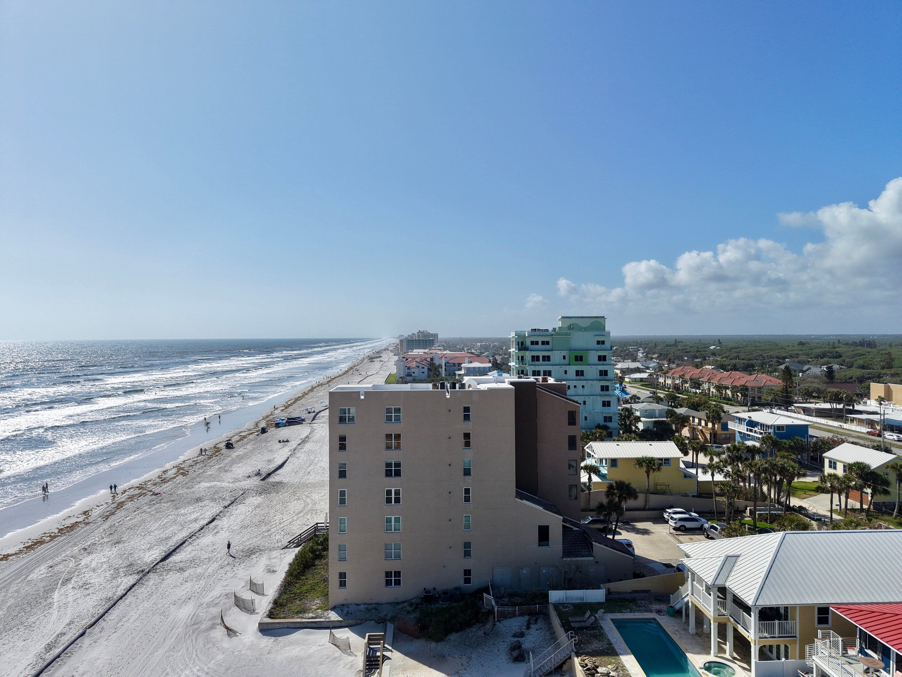 A coastal hotel with a pool, beach access, and a view of the ocean.
