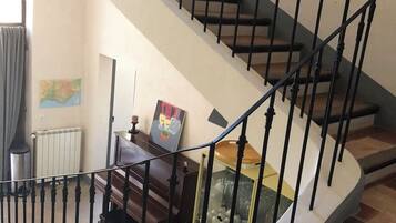 Eine Wendeltreppe mit schwarzen Geländern und Holzstufen, die zu einer oberen Etage führt.