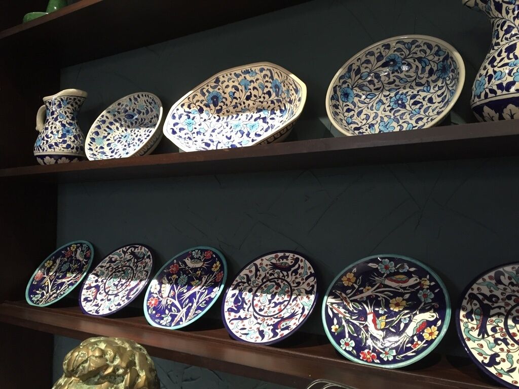 A display of ceramic plates with floral patterns on shelves.