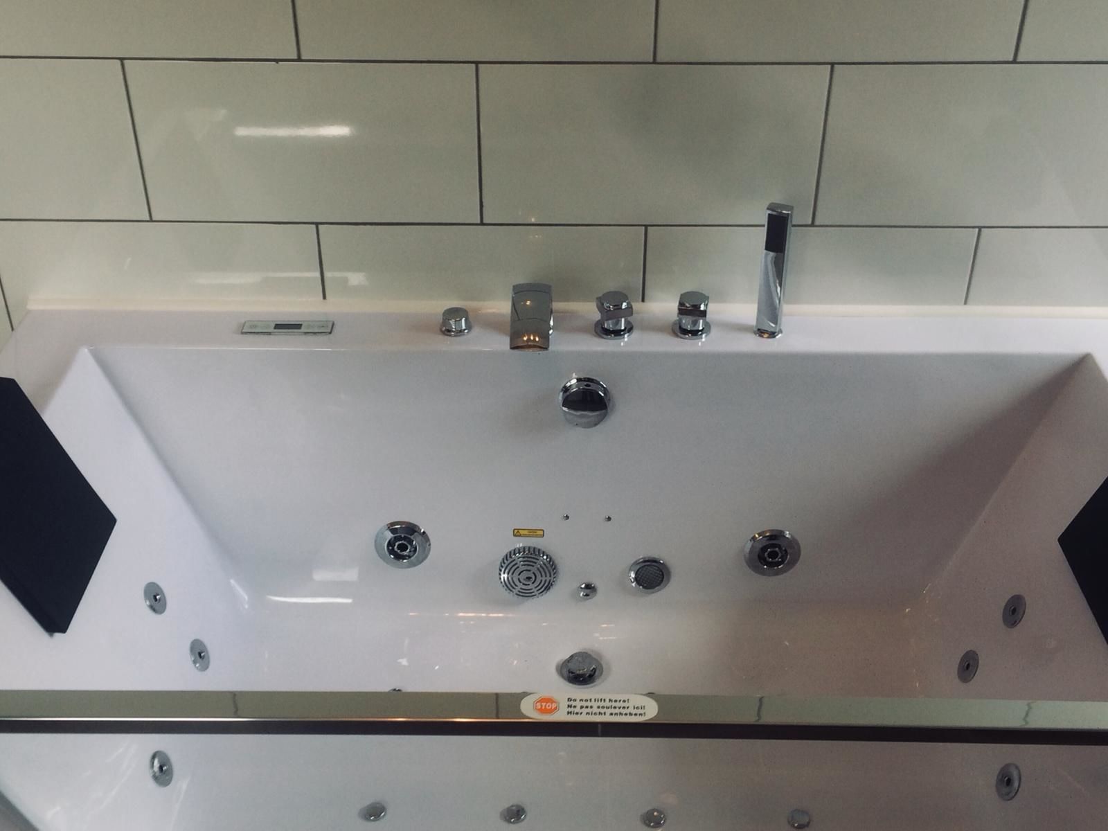 A modern bathroom with a white bathtub, chrome fixtures, and a glass-enclosed shower area.