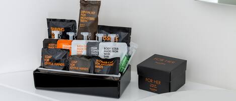 A black gift basket with toiletries and a black box labeled "FOR HER".