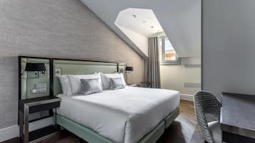 Una habitación de hotel moderna con una cama grande, un escritorio y una silla.