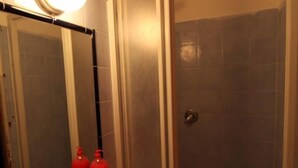 A bathroom with a sink, mirror, and shower. - Hostel Pink Floyd (Rome)