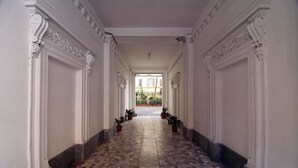 A corridor with patterned stone flooring, white walls, and columns. - Hostel Pink Floyd (Rome)