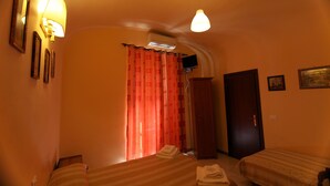 A hotel room with two beds, a wardrobe, a desk, and a television. - Hostel Pink Floyd (Rome)