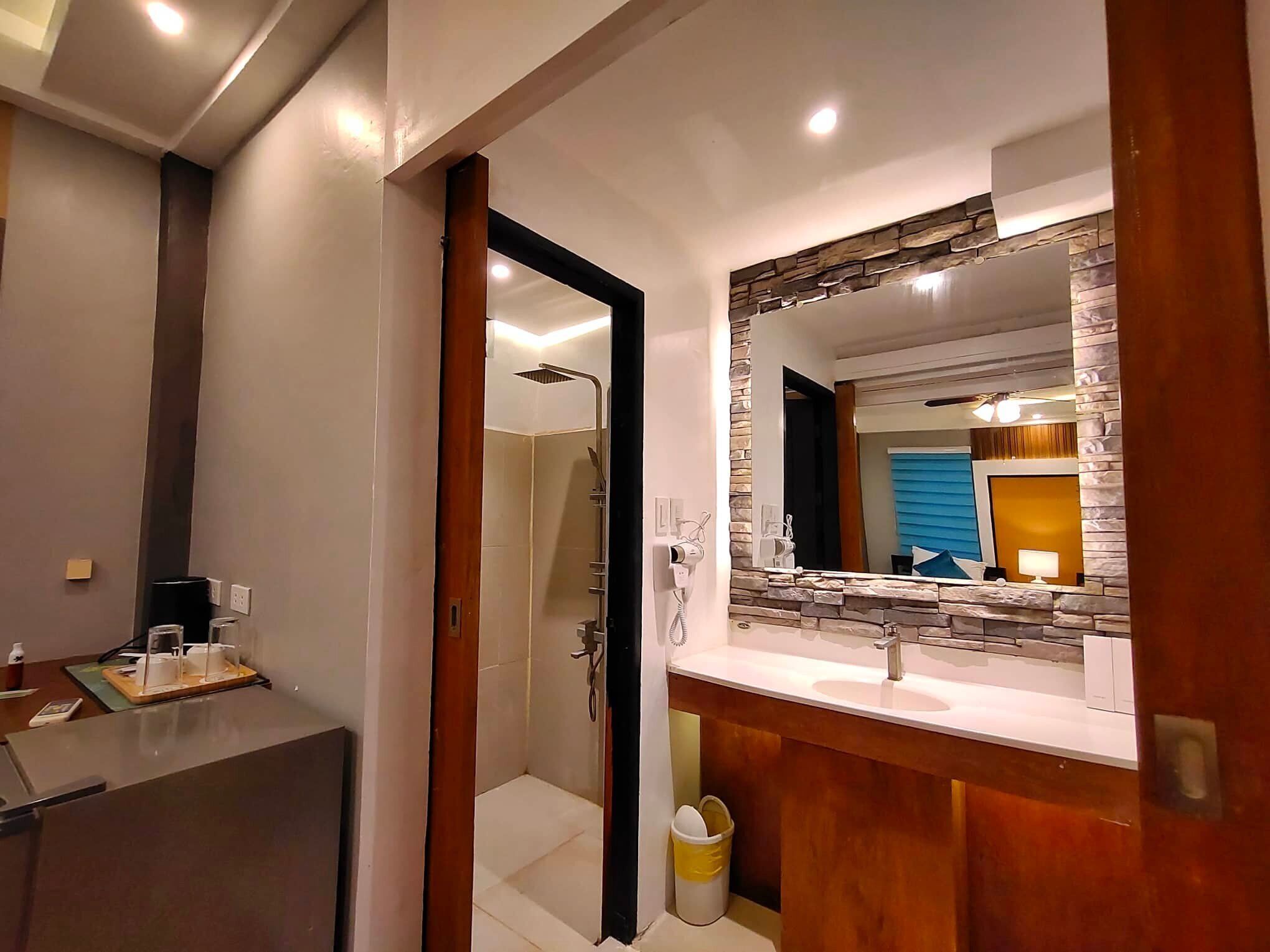 A modern bathroom with a shower, a vanity with a mirror, and a toilet.
