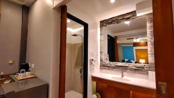 A modern bathroom with a shower, a vanity with a mirror, and a toilet.