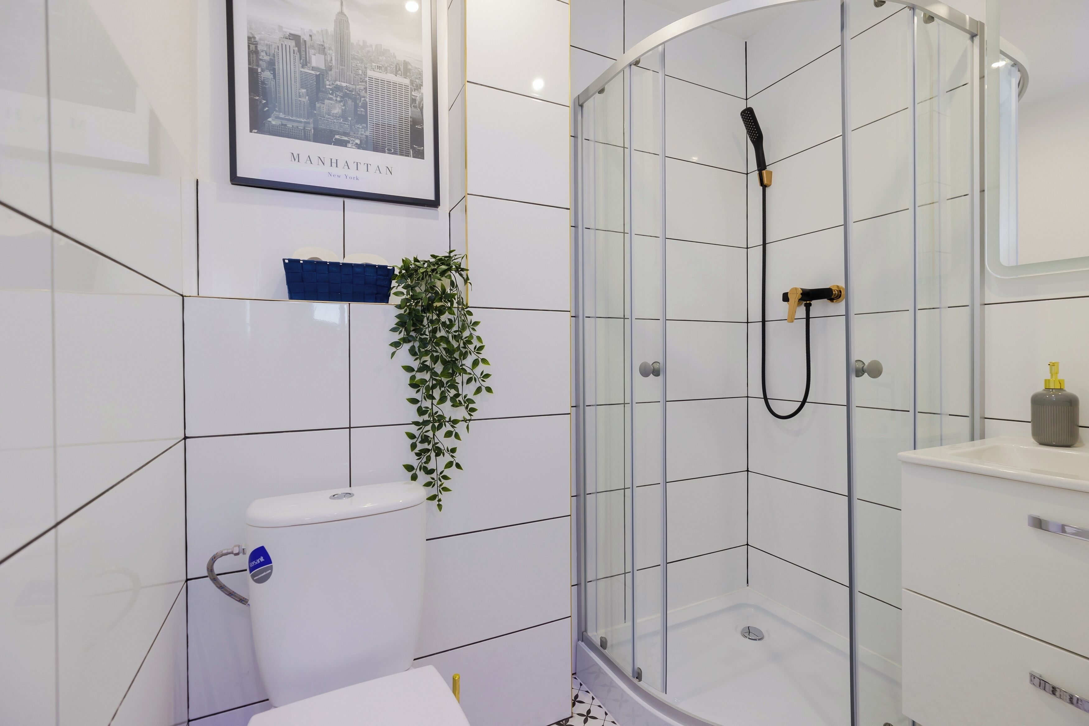 Um banheiro moderno com box de vidro, vaso sanitário e pia.