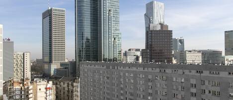 Un paisaje urbano con edificios modernos altos, incluyendo un rascacielos prominente con forma curva y un edificio con un patrón vertical distintivo.