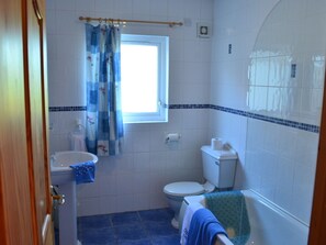 A small bathroom with a toilet, sink, and bathtub.