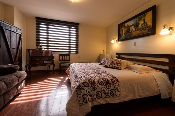 Un dormitorio con una cama grande, un escritorio y una silla.