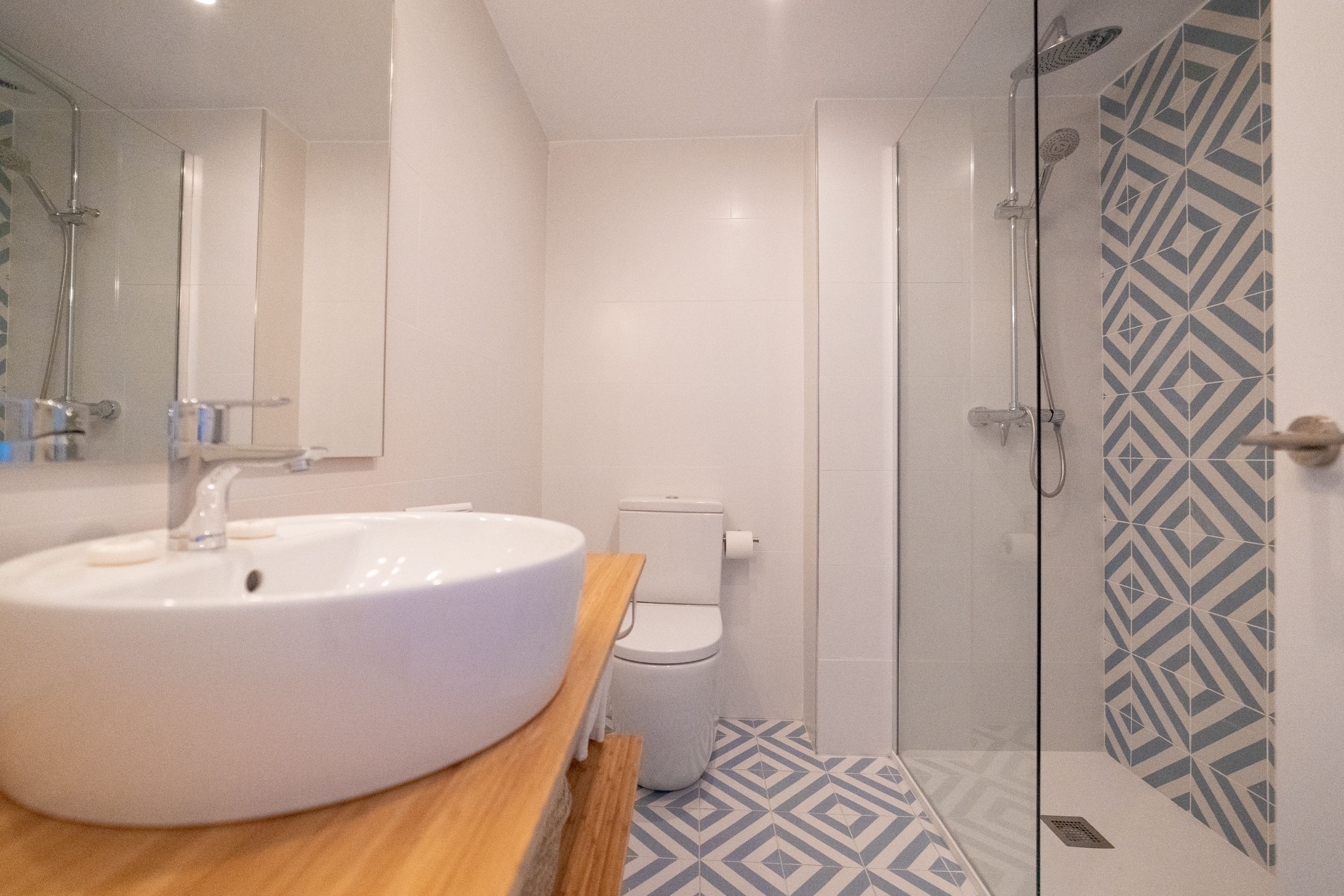 A bathroom with a white sink, toilet, and shower.