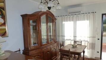 A dining area with a wooden cabinet, a chandelier, and a table with chairs.