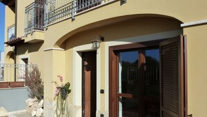 A building with a yellow facade, a wooden door, and a balcony with metal railings. - Sogno di Mare (Pula)