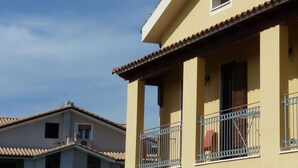 A yellow building with a balcony and arched windows. - Emozioni d'Estate (Pula)