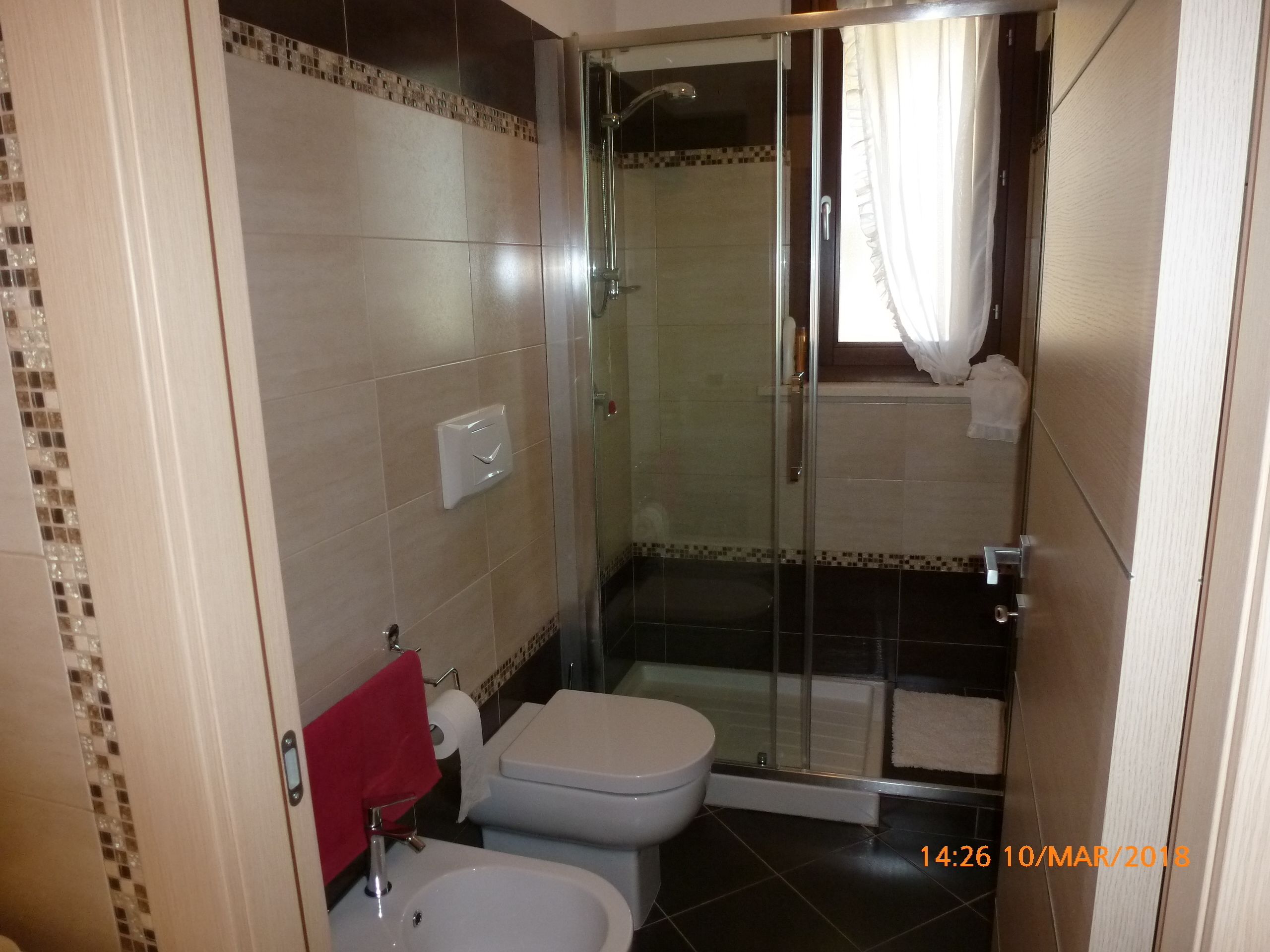 Un baño con ducha de vidrio, inodoro y lavamanos.