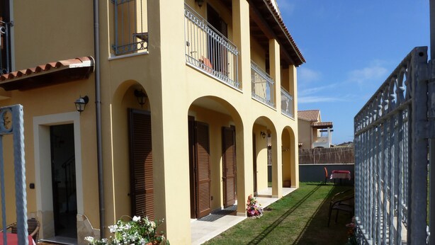 A two-story building with arched doorways and a balcony. - Emozioni d'Estate (Pula)