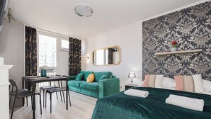 A modern bedroom with a bed, a sofa, a desk, and a chair.