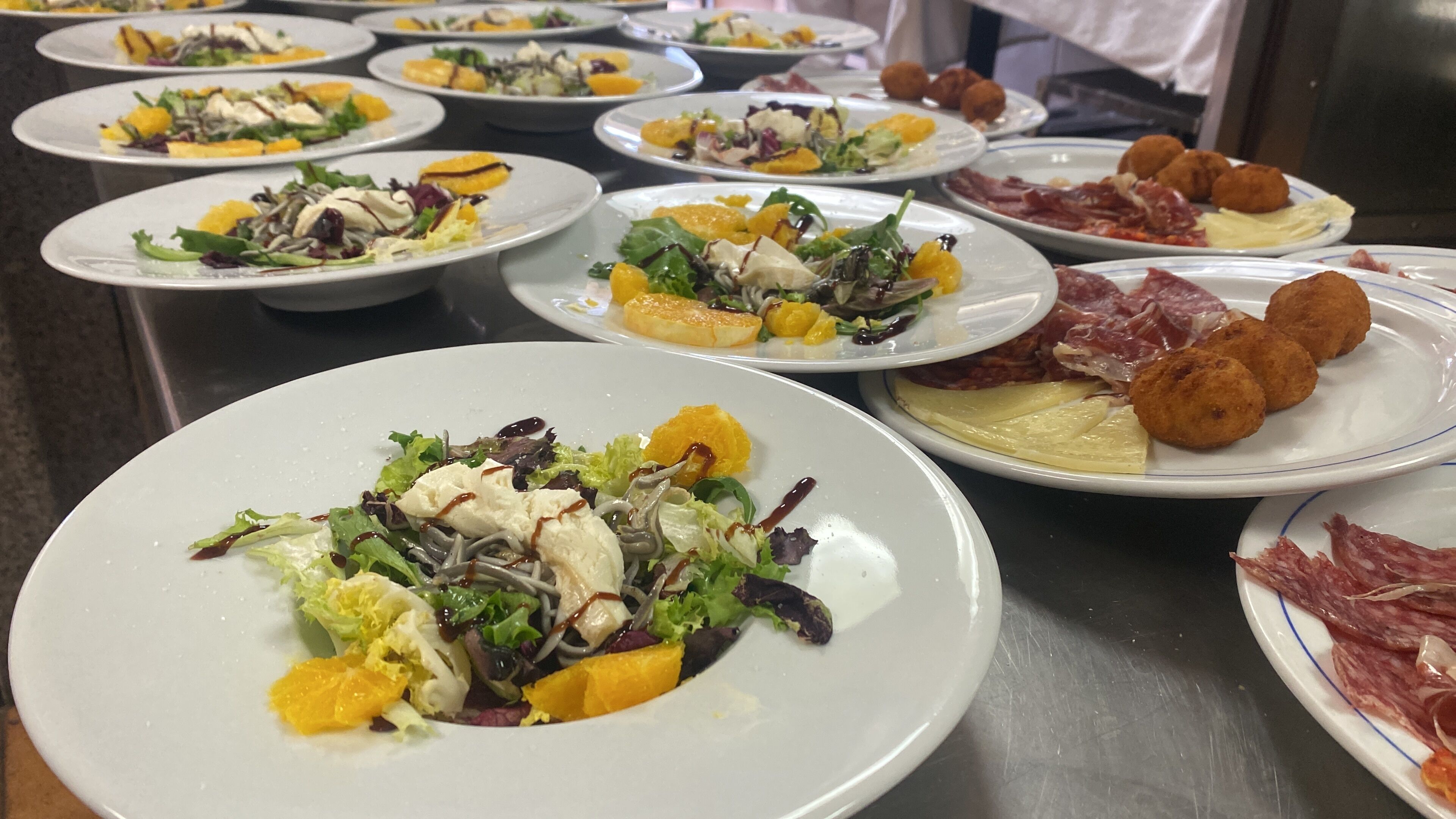A buffet with various dishes including salads, meats, and appetizers.