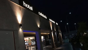 A hotel with a cafe and restaurant, featuring a modern design with illuminated signage and a paved outdoor area. - Hotel Moya (Navalmoral de la Mata)