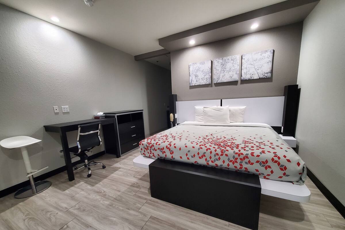 A modern bedroom with a bed, a desk, and a chair.