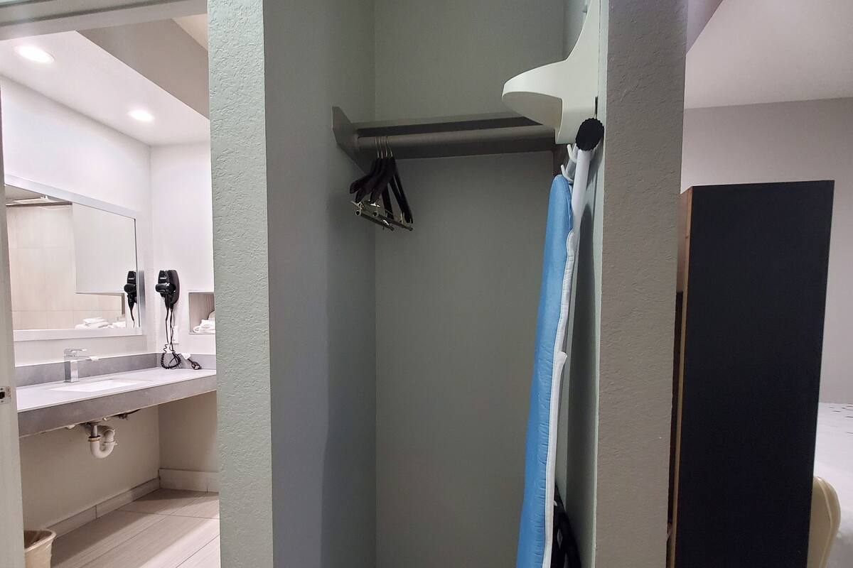 A bathroom with a shower, a towel rack, and a mirror.