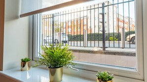 Ein Fenster mit drei Blumentöpfen auf der Fensterbank.
