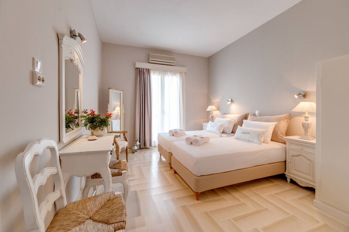 A bedroom with a large bed, bedside tables, a desk, and a chair.