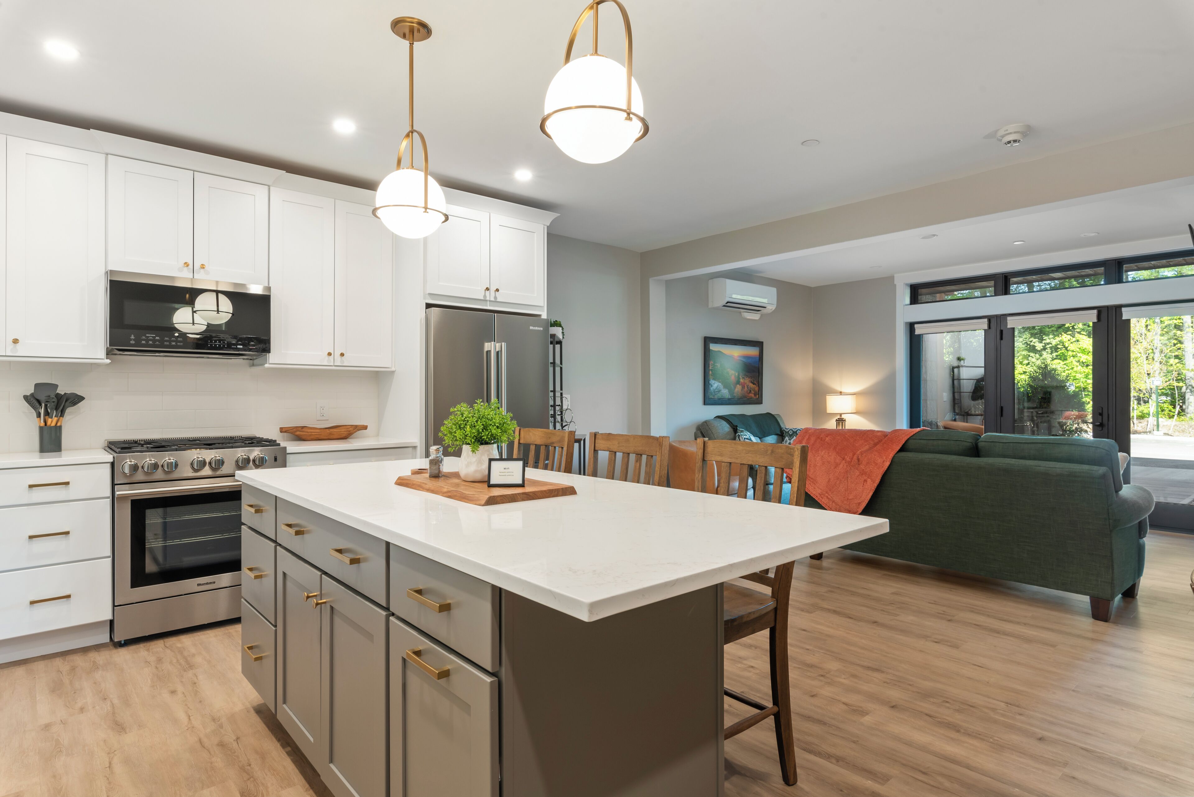 A modern kitchen with white cabinets, stainless steel appliances, and a central island.