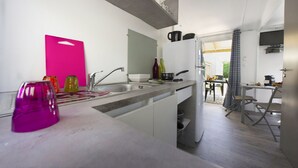 Eine moderne Küche mit weißer Arbeitsplatte, Spüle und Essbereich mit Tisch und Stühlen.