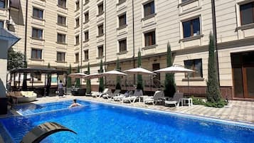 Ein Hotel mit Swimmingpool, Außenbereich und überdachtem Bereich.