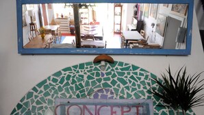 Um espelho com a placa "Concept Lounge" abaixo, rodeado por um painel de azulejos decorativos.