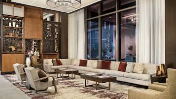 A modern living room with a sectional sofa, armchairs, a coffee table, and a bookshelf.