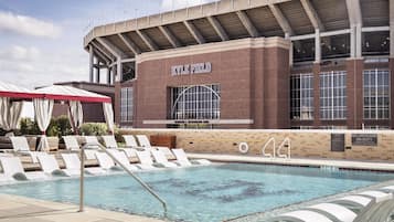 A swimming pool area with lounge chairs and a building labeled 'KYLE FIELD' in the background.