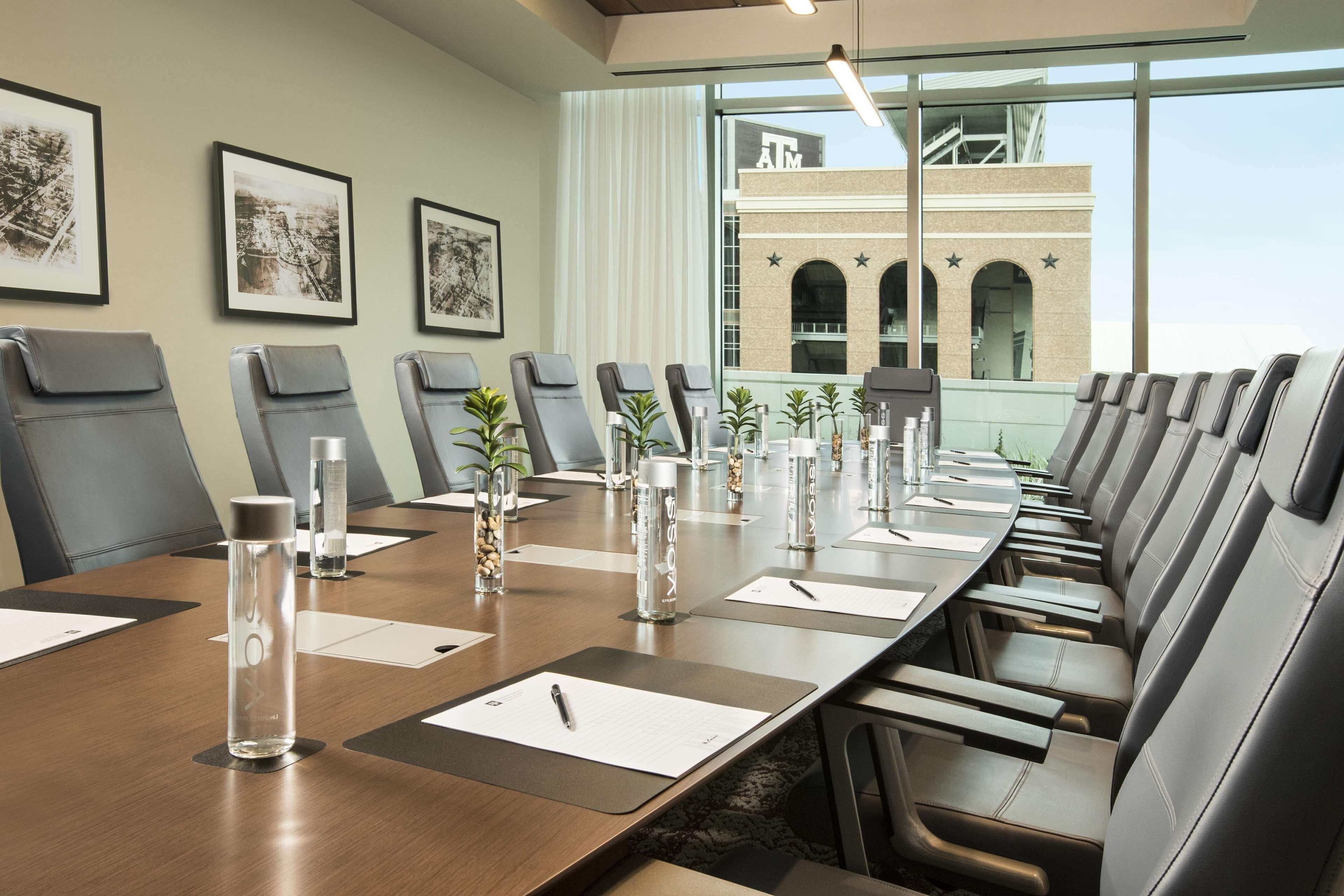 A conference room with a long table, chairs, and framed pictures on the wall.