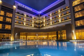 A modern hotel with a central courtyard pool, multiple balconies, and a prominent "TRYP BY WYNDHAM" sign. - TRYP by Wyndham Izmit (Basiskele)