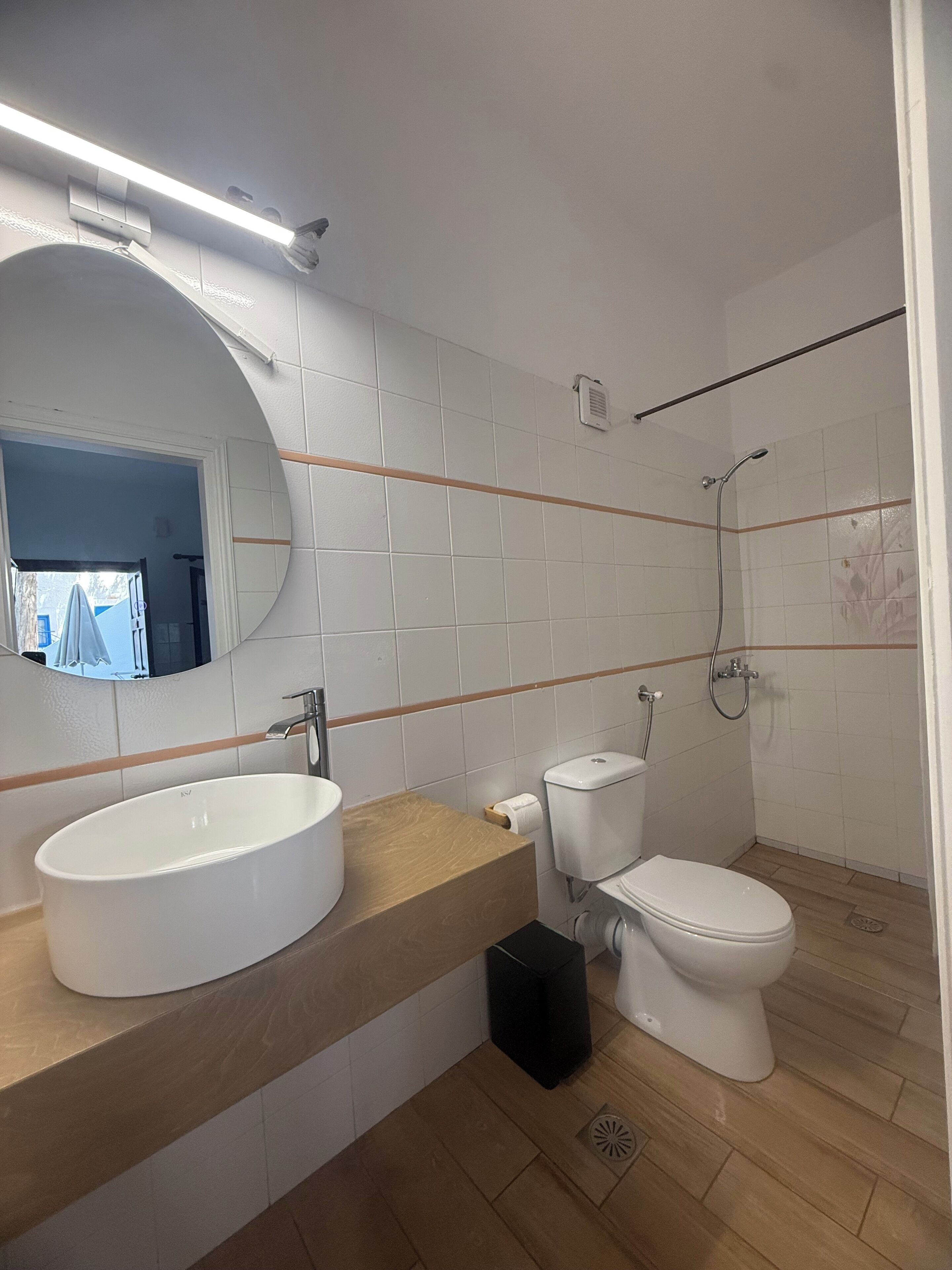 Moderni kylpyhuone, jossa on valkoinen pesuallas, wc ja suihku.