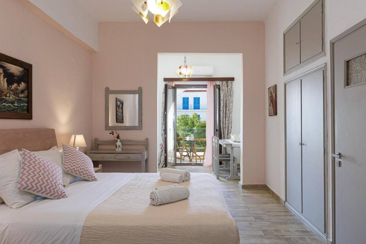 Ein Schlafzimmer mit einem Bett, Kissen, einem Schreibtisch und einem Kleiderschrank.