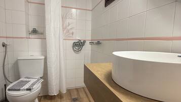 Et badeværelse med toilet, bruser og vask.