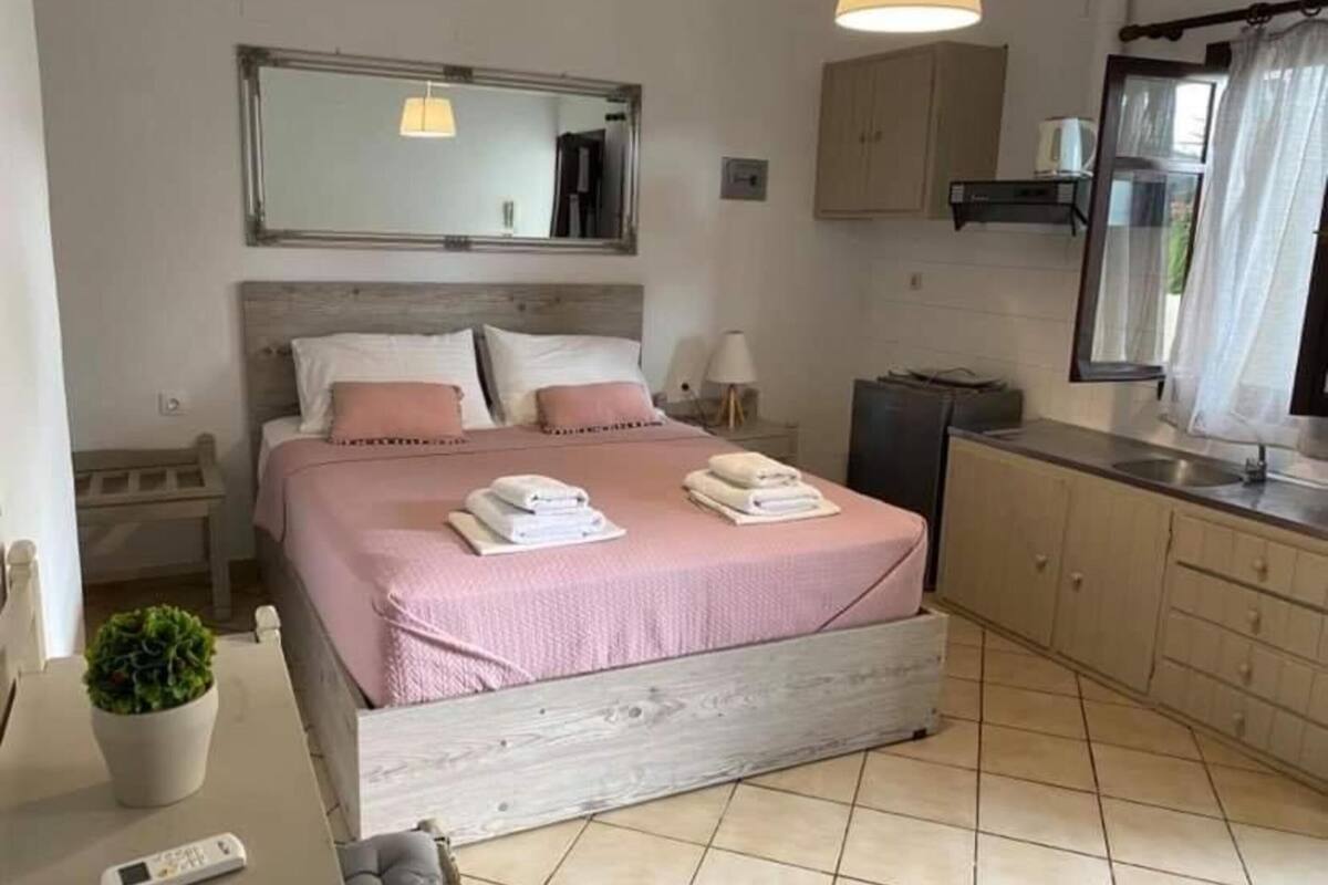 Ein Schlafzimmer mit Bett, Nachttischen, einem Spiegel, einer Zimmerpflanze und einer Nachttischlampe.