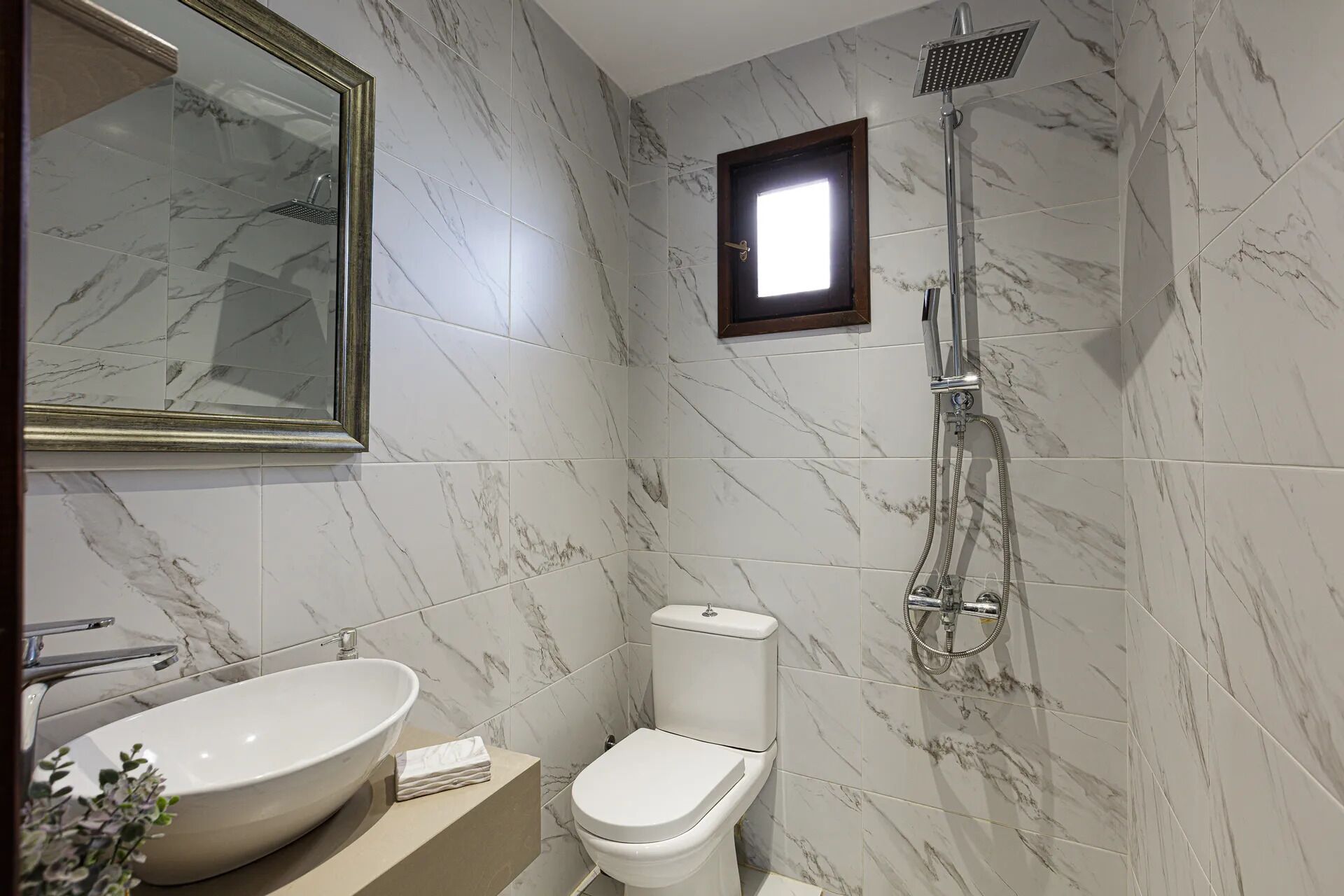 Ein Badezimmer mit einem großen Waschbecken, Toilette und Dusche.