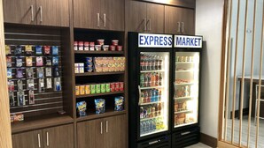 Een winkel met schappen vol snacks en dranken, en twee koelvitrines met de tekst 'EXPRESS MARKET'.
