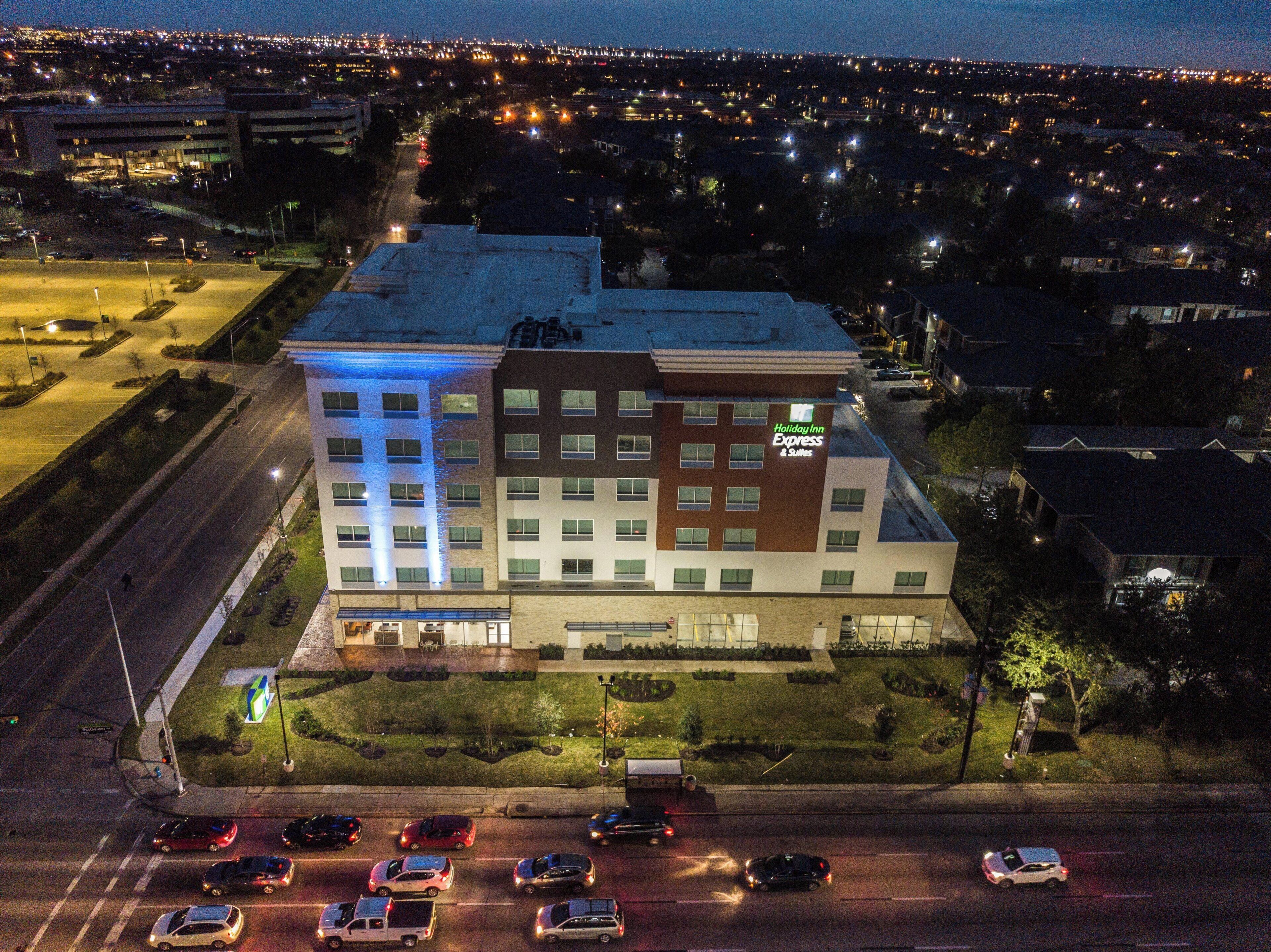 Un edificio de Holiday Inn Express de varios pisos con un estacionamiento al frente.