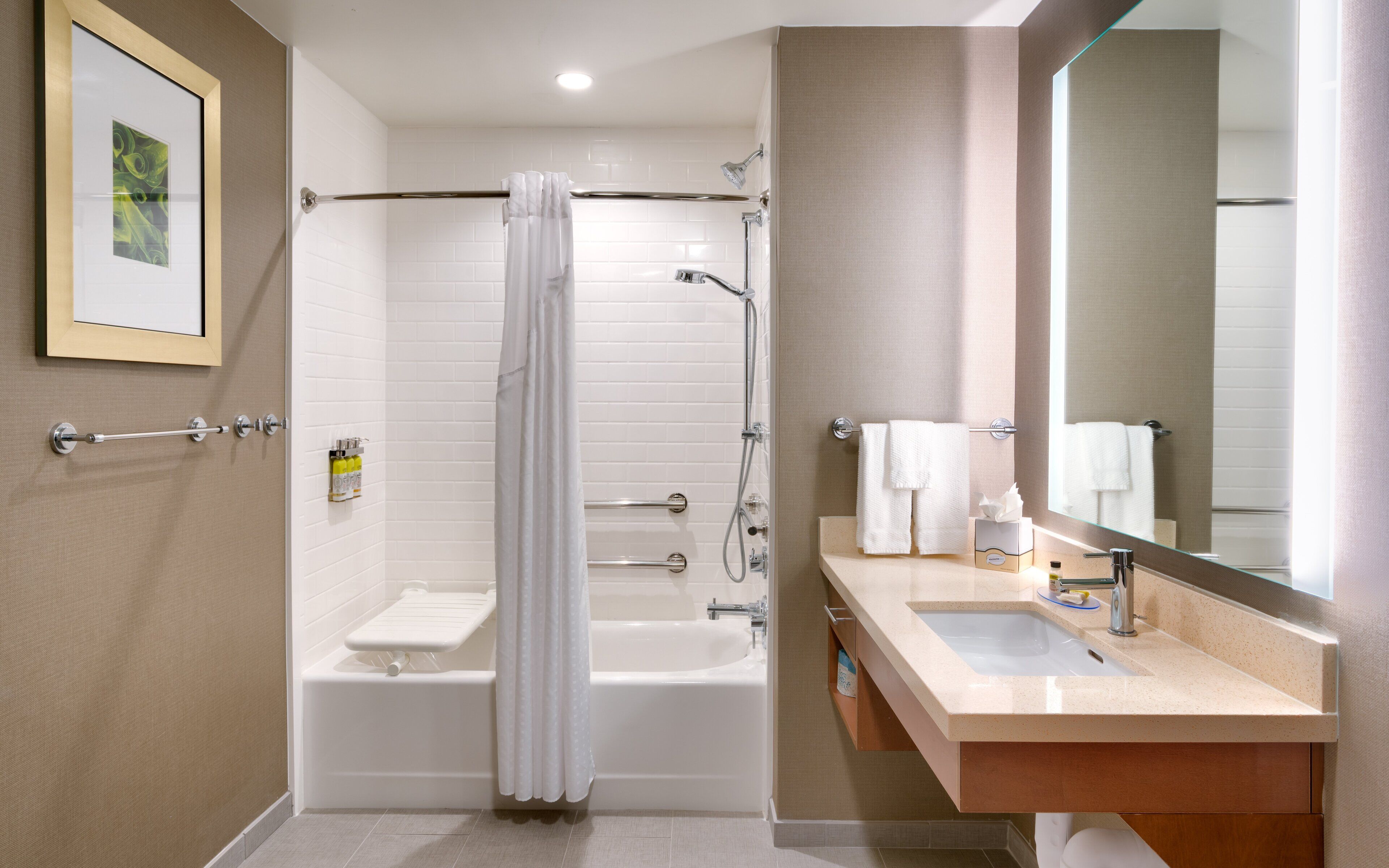 Een moderne badkamer met een bad, douche en wastafel.
