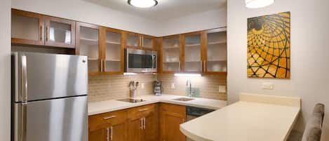 Una cocina moderna con armarios de madera, electrodomésticos de acero inoxidable, un microondas y una cafetera.
